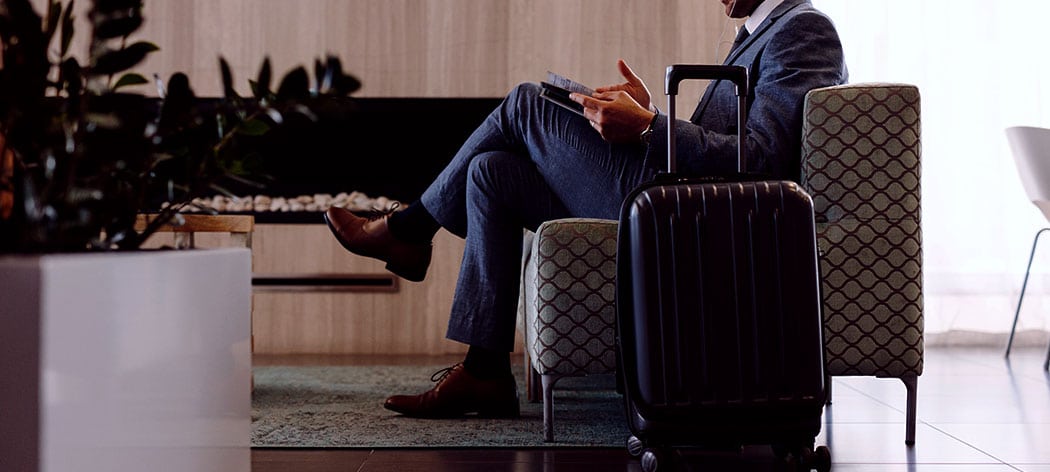 Mann sitter i sofa en en flyplass lounge på tur ut over grensene